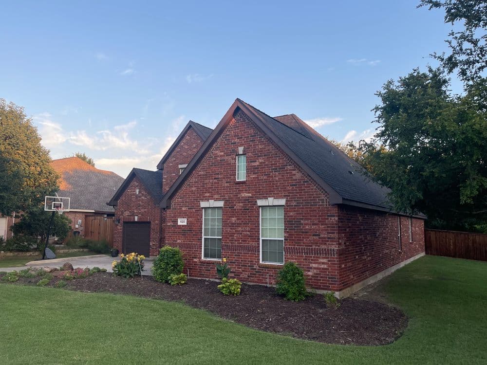 Charming brick house with well-maintained lawn and landscaping in a suburban neighborhood.